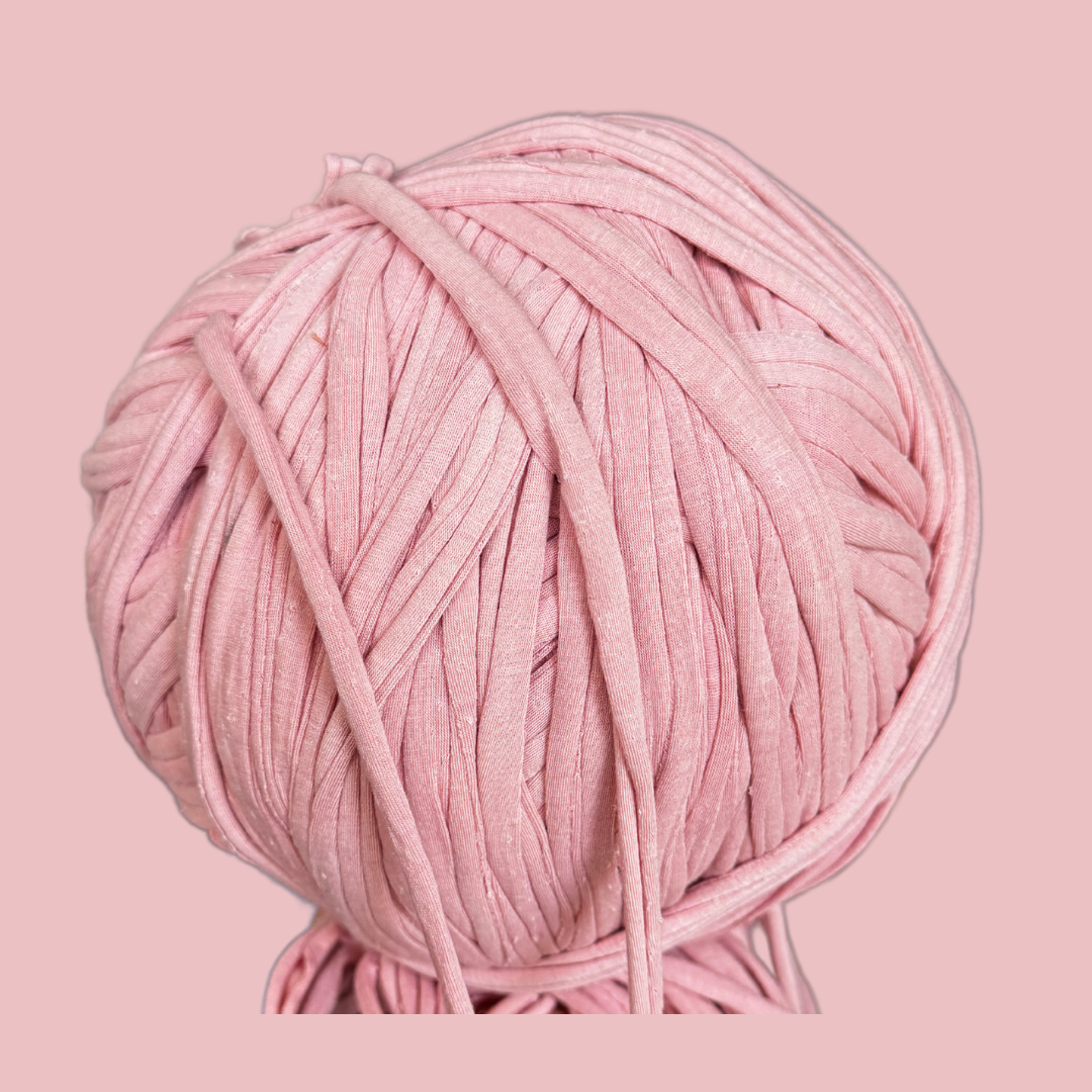 a ball of pink yarn on a pink background