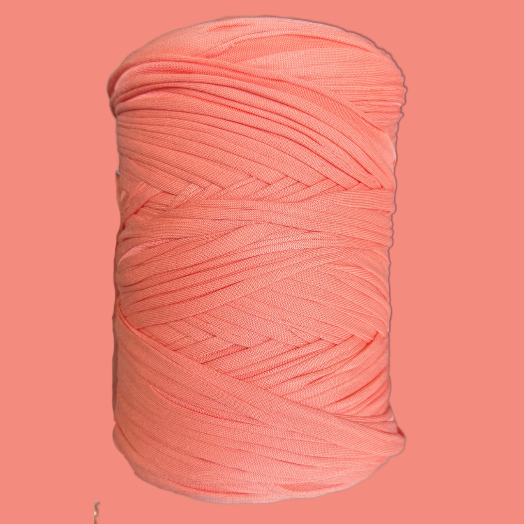 a spool of pink yarn on a pink background
