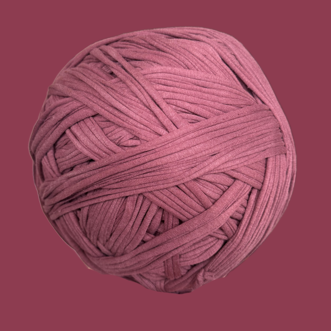 a ball of pink yarn on a pink background