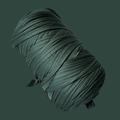 a spool of green thread on a black background