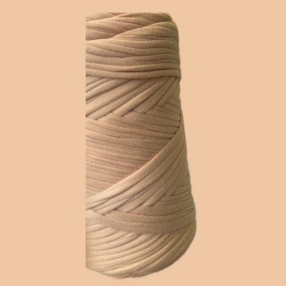 a spool of white thread on a beige background