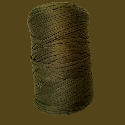 a spool of green yarn on a brown background