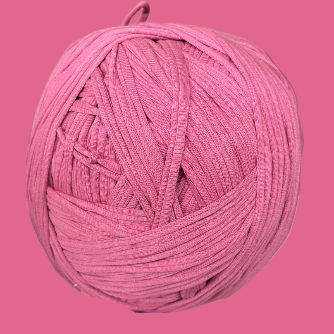 a ball of pink yarn on a pink background